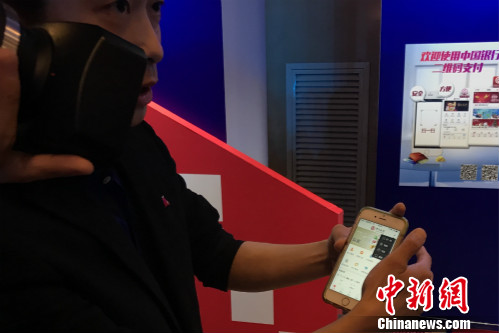 一位工作人員正在教體驗(yàn)者使用云閃付產(chǎn)品。<a target='_blank' href='http://www.chinanews.com/' >中新網(wǎng)</a> 種卿 攝