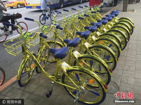 資料圖：6月8日，北京，金色共享單車現(xiàn)身朝陽區(qū)望京街頭。該共享單車配備充電模塊，可以給手機充電。 圖片來源：視覺中國
