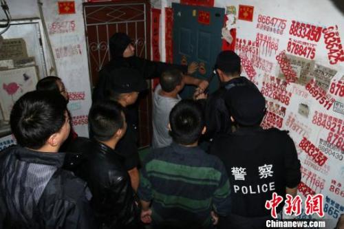 資料圖：2016年11月19日，福建延平，民警用撬棍撬開(kāi)傳銷窩點(diǎn)防盜門。　丁晨 攝