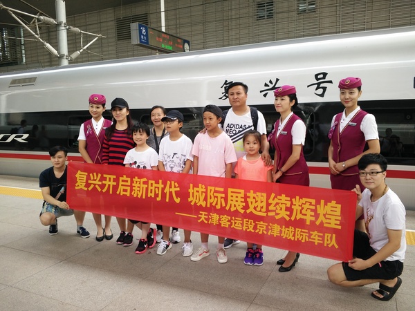 京津城際迎來“復(fù)興號(hào)“，旅客與乘務(wù)員合影留念