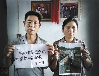 8月20日，河南信陽(yáng)，鄧杰的家中，鄧杰的父母拿著兒子的照片，盼望兒子平安回家。