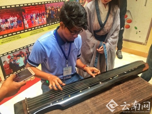 孟加拉國少年在彈奏古琴。