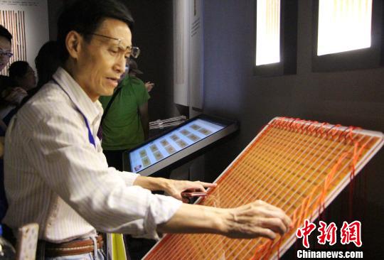 圖為參展觀眾在現(xiàn)場體驗(yàn)古代算表的計算方式?！≮w曉 攝