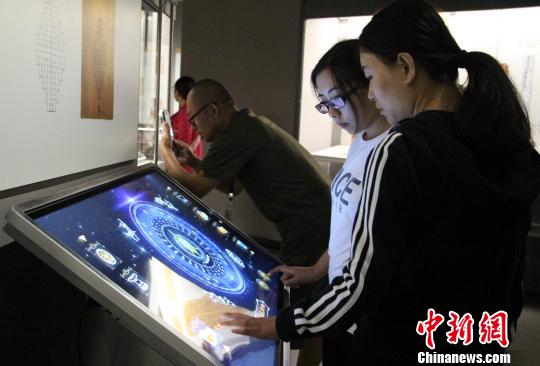 圖為參展觀眾在現(xiàn)場體驗(yàn)互動模具?！≮w曉 攝