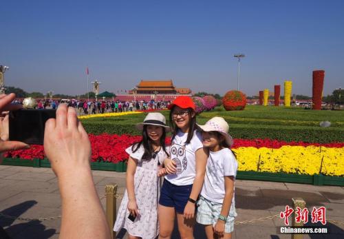 9月29日，三位小游客在北京天安門廣場國慶花壇前留影。 <a target='_blank' href='http://www.chinanews.com/'>中新社</a>記者 賈天勇 攝