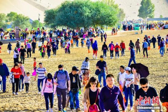 今年“十一”黃金周期間，絲綢之路國際旅游名城甘肅敦煌天氣晴好，景色如畫。敦煌深厚的歷史文化和雄渾的大漠風(fēng)光，吸引了大批海內(nèi)外游客紛至沓來，敦煌旅游再度火爆。10月3日，鳴沙山月牙泉景區(qū)接待游客29524人次，創(chuàng)景區(qū)單日接待游客人數(shù)最高紀(jì)錄。據(jù)敦煌市旅游局統(tǒng)計：截至10月3日，敦煌市共接待中外游客11.07萬人次，同比增長17.14%，實現(xiàn)旅游收入1.12億元，同比增長17.94%。其中，莫高窟接待游客51485人次，同比增長8.45%；鳴沙山月牙泉景區(qū)接待游客65386人次，同比增長13.75%；雅丹景區(qū)接待游客10787人次，同比增長18.93%；陽關(guān)景區(qū)接待8924人次，同比增長48....