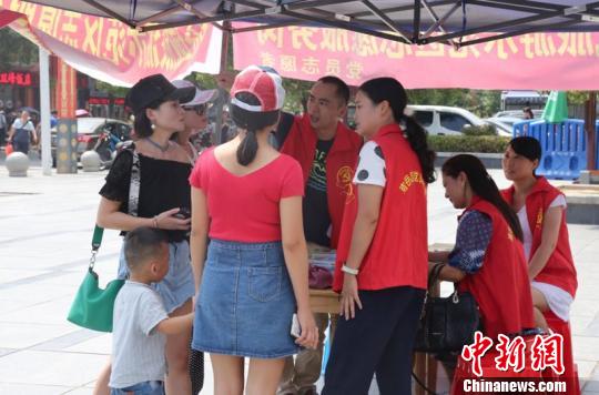 景區(qū)志愿者為游客解疑答惑、免費(fèi)發(fā)放南岳旅游地圖、提供景區(qū)線(xiàn)路指引?！∥柠愘F 攝