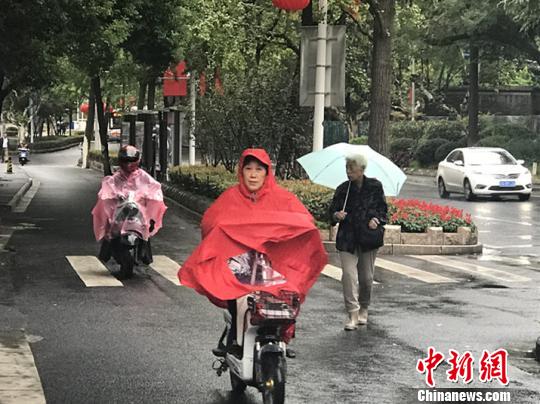 11日，南京迎來降溫降雨。圖為市民披上雨衣出行。　楊顏慈 攝