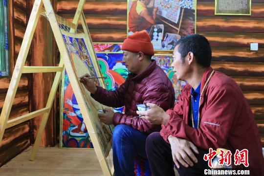 圖為高佐甲澤與徒弟阿阿扎巴繪制唐卡。　王鵬 攝
