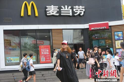 資料圖：民眾從山西太原一麥當(dāng)勞前經(jīng)過(guò)。<a target='_blank' href='http://www.chinanews.com/'>中新社</a>記者 張?jiān)?攝