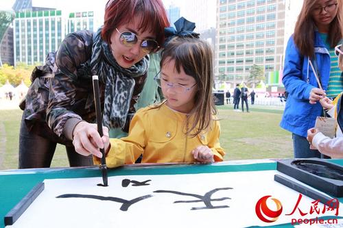 中國僑網(wǎng)韓國小朋友學(xué)寫漢字。