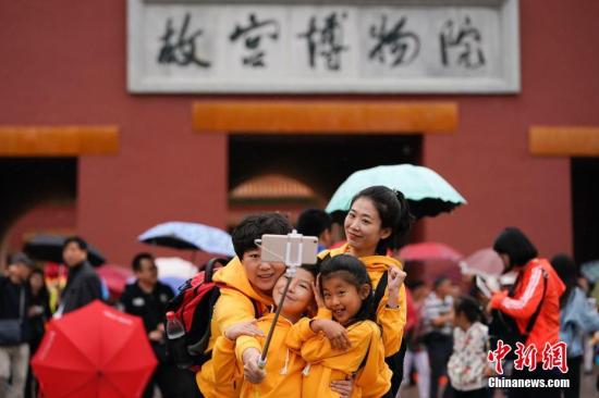 10月2日，北京小雨，游客在故宮博物院游覽。根據(jù)國家旅游局數(shù)據(jù)中心綜合測算，中國國慶假期首日，全國當天共接待游客1.13億人次，同比增長10.5%，實現(xiàn)旅游收入965億元，同比增長12.2%。<a target='_blank' href='http://www.chinanews.com/'>中新社</a>記者 杜洋 攝