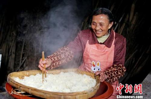 韓進(jìn)先把蒸熟的糯米在筲箕中進(jìn)行攤涼?！顫?攝
