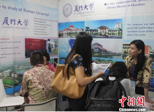 圖為到廈門大學(xué)展位咨詢的印尼學(xué)生和家長(zhǎng)絡(luò)繹不絕?！×钟纻?攝