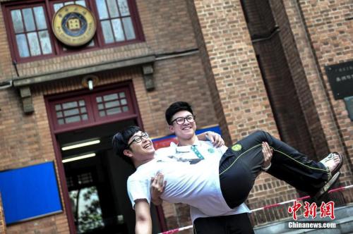 資料圖：一名高考考生抱起同學(xué)在考場(chǎng)前合影留念。<a target='_blank' href='http://www.chinanews.com/'>中新社</a>記者 陳驥旻 攝