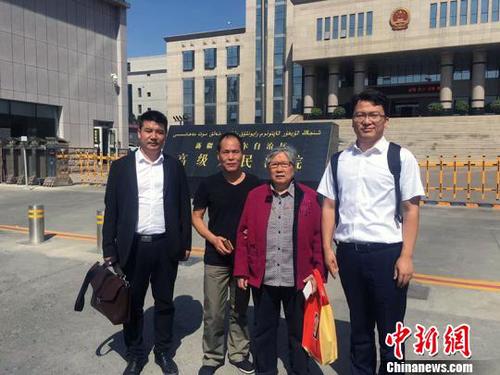 王興律師與李碧貞及周遠(yuǎn)在新疆高級人民法院門前合影?！⊥跖d 攝