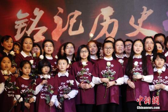 當(dāng)?shù)貢r(shí)間12月9日，加拿大安大略省各界華人共同舉辦的“南京大屠殺80周年追思會(huì)”在多倫多舉行。來(lái)自華人社區(qū)及其他多個(gè)族裔社區(qū)的逾千名代表參加此次主題為“銘記歷史，祈愿和平”的追思會(huì)。圖為社區(qū)人士與孩子們?cè)谧匪紩?huì)上合唱《讓世界充滿愛(ài)》。 <a target='_blank' href='http://www.chinanews.com/'>中新社</a>記者 余瑞冬 攝