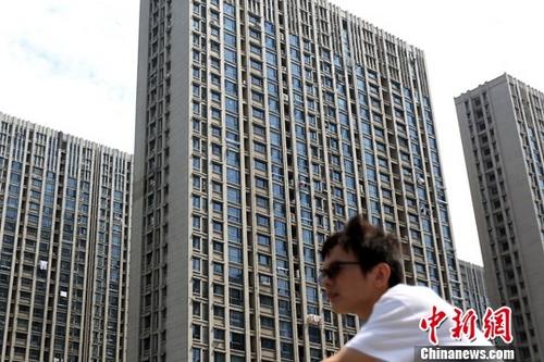 10月19日，據中國國家統(tǒng)計局網站消息，1-9月份，商品房銷售面積116006萬平方米，同比增長10.3%，增速比1-8月份回落2.4個百分點。商品房銷售額91904億元，增長14.6%，增速回落2.6個百分點。圖為市民從南京一處樓盤前經過。(資料圖片)<a target='_blank' href='http://www.chinanews.com/'>中新社</a>記者 泱波 攝