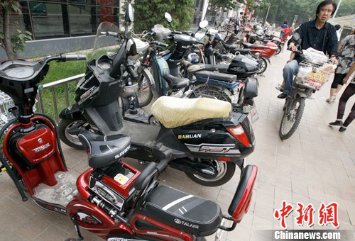 近日，公安部、工信部、國(guó)家工商總局、國(guó)家質(zhì)檢總局等四部委聯(lián)合下文，要求整改當(dāng)下電動(dòng)自行車(chē)產(chǎn)業(yè)。圖為5月29日，北京某大型超市前的自行車(chē)停車(chē)場(chǎng)中多半為電動(dòng)車(chē)。<a target='_blank' href='http://www.chinanews.com/'>中新社</a>發(fā) 張宇 攝