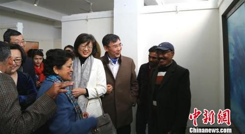 中國僑網(wǎng)圖為參展嘉賓觀看畫作?！＄娦馈z