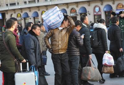 　昨日，北京站，乘客背著行李準備進站乘車。本版攝影/新京報記者 王貴彬 朱駿 實習生 陳婉婷