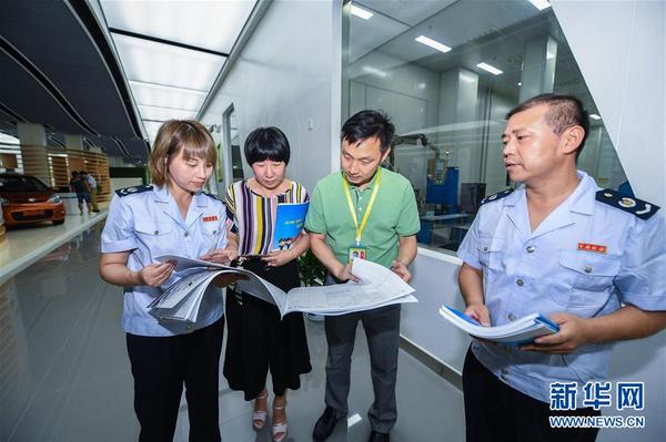 浙江省長興縣地稅局工作人員在新能源企業(yè)超威集團(tuán)給相應(yīng)部門工作人員（左二、左三）介紹最新的稅收優(yōu)惠政策（2017年7月14日攝）。8