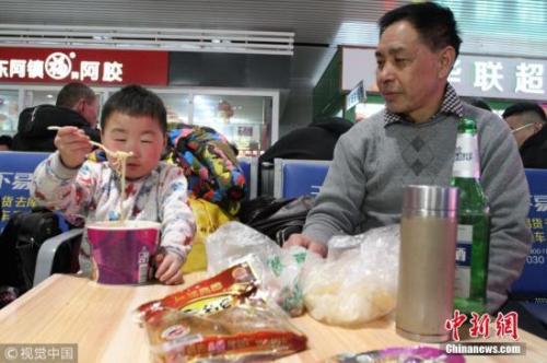 資料圖：春運(yùn)途中，有旅客喝著小酒就花生。圖片來(lái)源：視覺(jué)中國(guó)