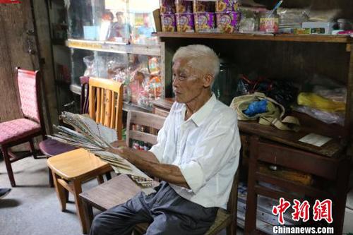 圖為韋宣周在展示其珍藏的“家書”?！×周?攝