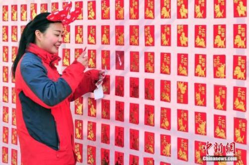 資料圖：2018年2月16日，大年初一，游客來(lái)到天津方特歡樂世界紅包墻前搶包紅。<a target='_blank' href='http://www.chinanews.com/'>中新社</a>記者 佟郁 攝