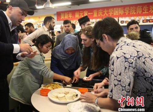 中國(guó)僑網(wǎng)圖為重慶大學(xué)留學(xué)生包餃子和湯圓共慶元宵節(jié)?！＄娦馈z