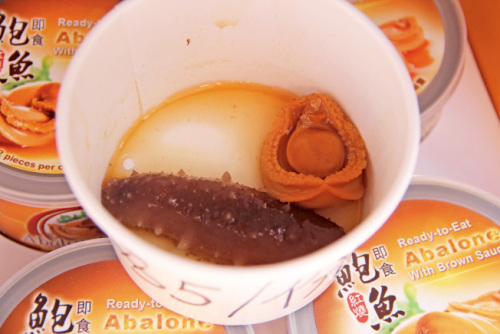 5美元一份的鮑魚海參餐，許多游人買來邊走邊吃。（美國《世界日報》／記者李晗 攝影）