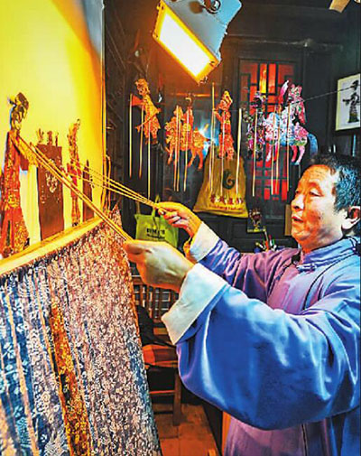 山東臺(tái)兒莊古城非遺文化展示區(qū)，現(xiàn)年60歲的國家級(jí)非物質(zhì)文化遺產(chǎn)魯南皮影戲傳承人陳守科正在向游客表演皮影戲，讓游客們感受傳統(tǒng)文化的魅力。高啟民攝