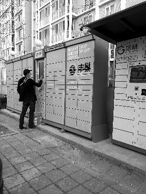 快遞員掃碼將快遞包裹逐一放入柜子中。圖片來源：北京晨報(bào)