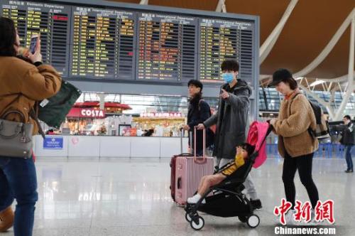 旅客帶著孩子前往辦票柜臺(tái)辦理登機(jī)手續(xù)?！∫罅⑶?攝