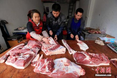 居民在家中切豬肉。譚凱興 攝