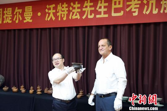  提爾曼-沃特法（右）向湖南省博物館捐贈巴考沉船代表文物明景德鎮(zhèn)窯醬釉三足香爐。湖南省博物館供圖