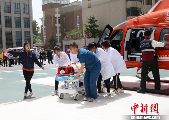 5月23日，遼寧省人民醫(yī)院完成中國(guó)東北首例異地航空醫(yī)療轉(zhuǎn)運(yùn)任務(wù)。圖為急救人員立即將患者抬上急救床?！≈烀饔?攝