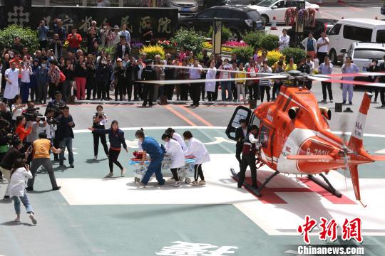 5月23日，遼寧省人民醫(yī)院完成中國(guó)東北首例異地航空醫(yī)療轉(zhuǎn)運(yùn)任務(wù)。圖為急救人員立即將患者抬上急救床。　朱明宇 攝