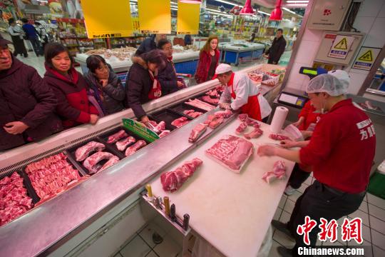 山西太原，超市員工在為民眾分解豬肉。張云 攝