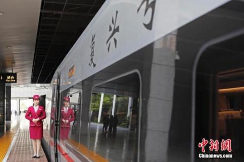 資料圖：4月10日，列車(chē)員在“復(fù)興號(hào)”列車(chē)旁迎接旅客的到來(lái)。 中新社記者 殷立勤 攝