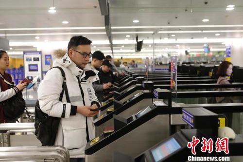 資料圖：旅客在浦東機場T2航站樓出境大廳內(nèi)掃登機牌、刷護照、按指紋拍照片，10多秒就能自助出境通關(guān)?！∫罅⑶凇z