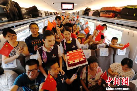 長(zhǎng)編組“復(fù)興號(hào)”動(dòng)車組，列車員與旅客慶祝這一時(shí)刻?！∫罅⑶?攝