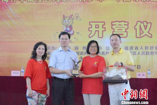 中國僑網(wǎng)7月9日，2018年海外華裔及臺灣地區(qū)青少年“中國尋根之旅”夏令營——福建洛江營開營式上，主辦方互贈紀(jì)念品?！O虹　攝