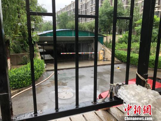 圖為24日上午河北廊坊市某小區(qū)車庫積水嚴重，物業(yè)加開臨時管泵排水?！∷蚊魸?攝