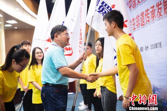 華僑大學校長助理張云波為2018年“中華文化之旅“6個研習營的學生代表授旗。伊凡 攝