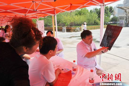 圖為醫(yī)學(xué)專家為患者講解病情?！≈旖ㄜ?攝
