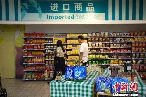 民眾在超市進(jìn)口商品貨架前選購商品。　張?jiān)?攝