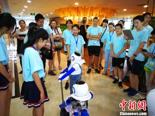 營員參觀高新技術(shù)企業(yè)，與趙宇機器人互動。　楊杰英 攝