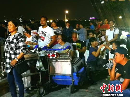 候機廳外不少滯留旅客將行李放在手推車上，靠著休息?！￡P向東 攝