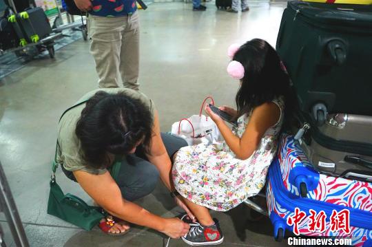 候機廳外不少滯留旅客將行李放在手推車上，靠著休息?！￡P向東 攝